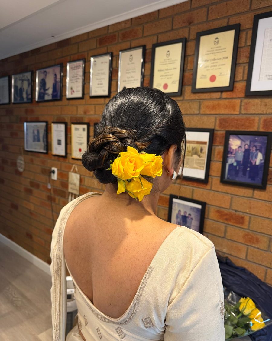 Low braided bun dressed with yellow roses