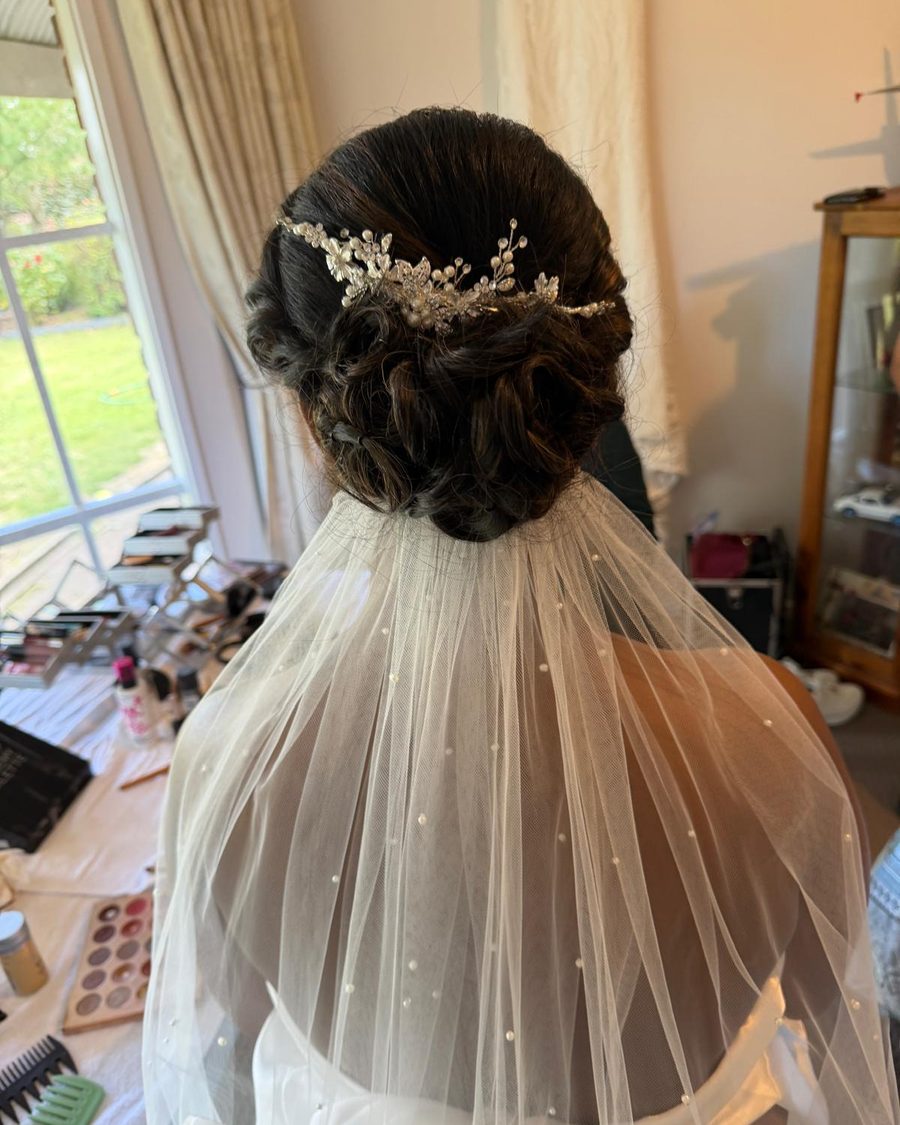Bridal updo with a jewelled hairpiece and veil